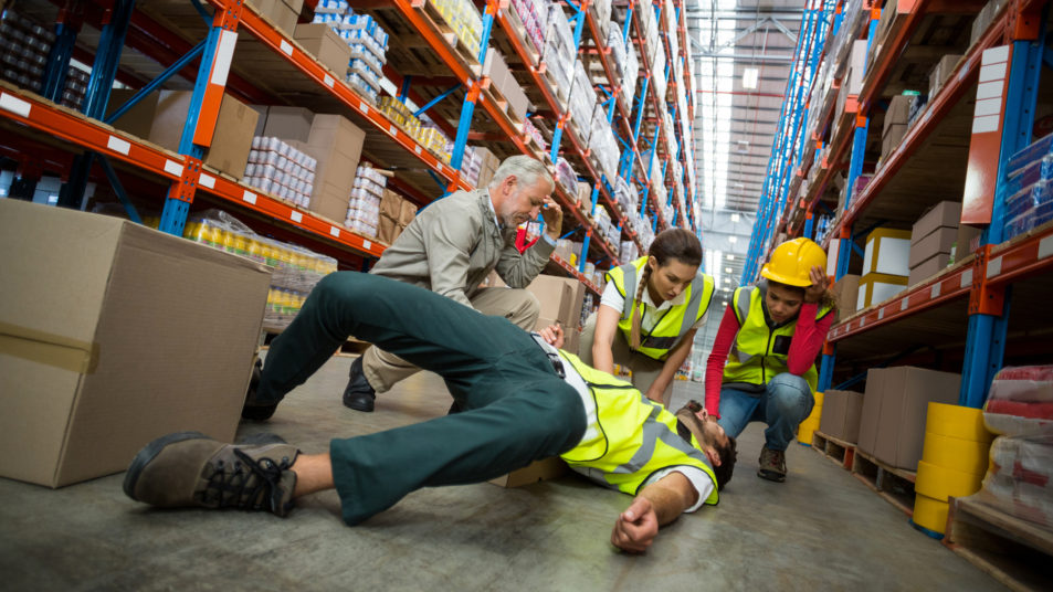 Worker fallen down while carrying cardboard boxes in warehouse